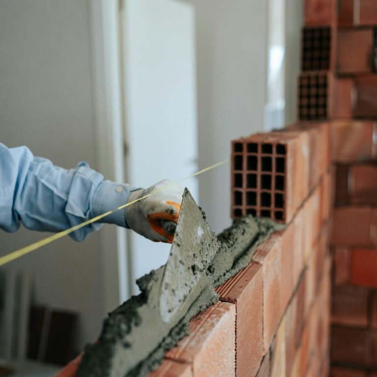 Maçon posant des briques sur un chantier de construction — Loganestim+